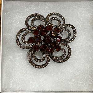 Dark silver toned floral shaped pin with brown cognac toned stones.